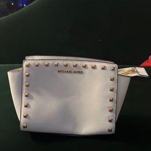 Michael Kors white purse with gold square buttons.